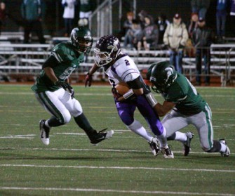 Tevin Gray fights to break free from Skyline defenders in a first round playoff game.